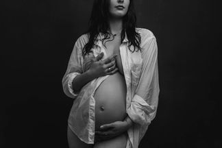 nude maternity photography in NYC studio with dramatic lighting showcasing pregnant woman