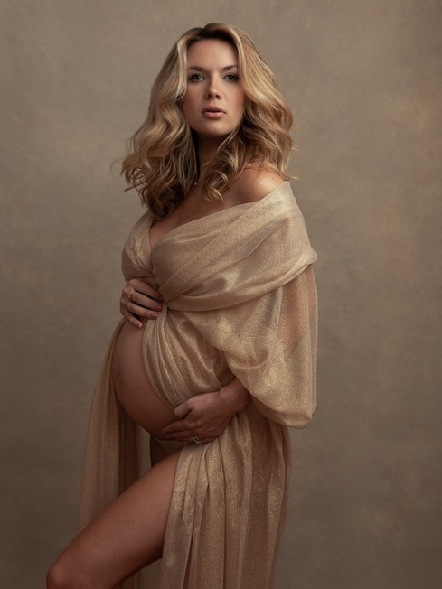 Elegant maternity portrait of a pregnant woman wrapped in silk fabric photographed by Alice Prenat in New York City.
