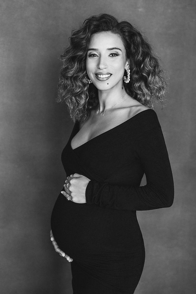 Expecting mother in elegant black maternity dress during NYC photo session