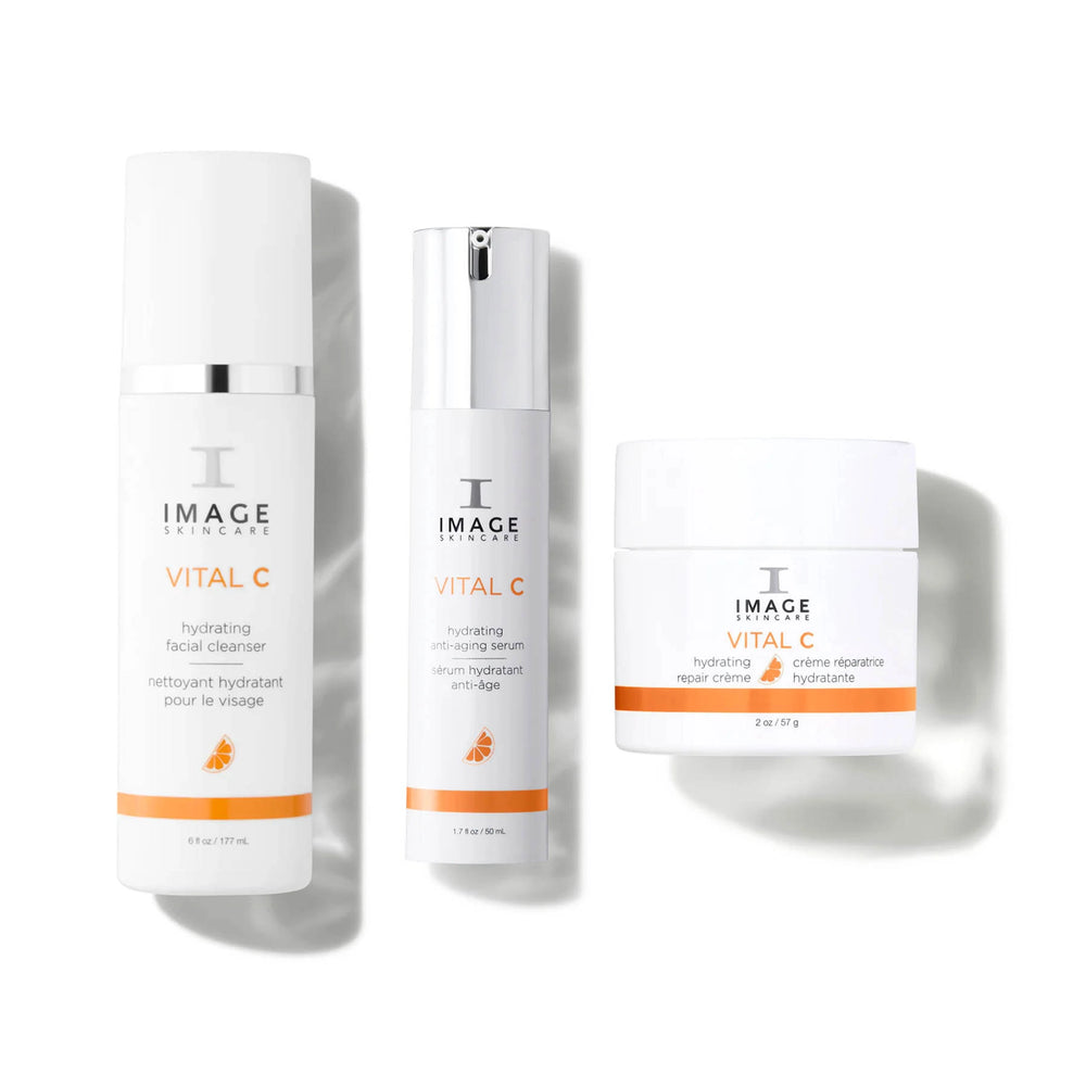 Drei weisse Produkte der IMAGE Skincare VITAL C Linie, darunter der Hydrating Facial Cleanser und das Anti-Aging Serum, auf hellem Hintergrund.