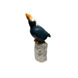 Ceramic puffin sculpture on a stump, dark blue and white.