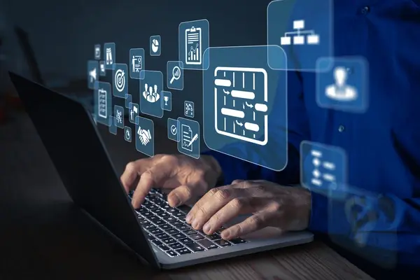 Hands typing on laptop with floating digital icons like charts and graphs. Dark background, blue light glow, tech-focused atmosphere.