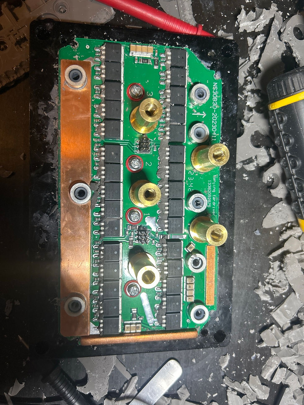 Exposed motor-controller power board with rows of MOSFETs and copper busbars after potting compound removal.