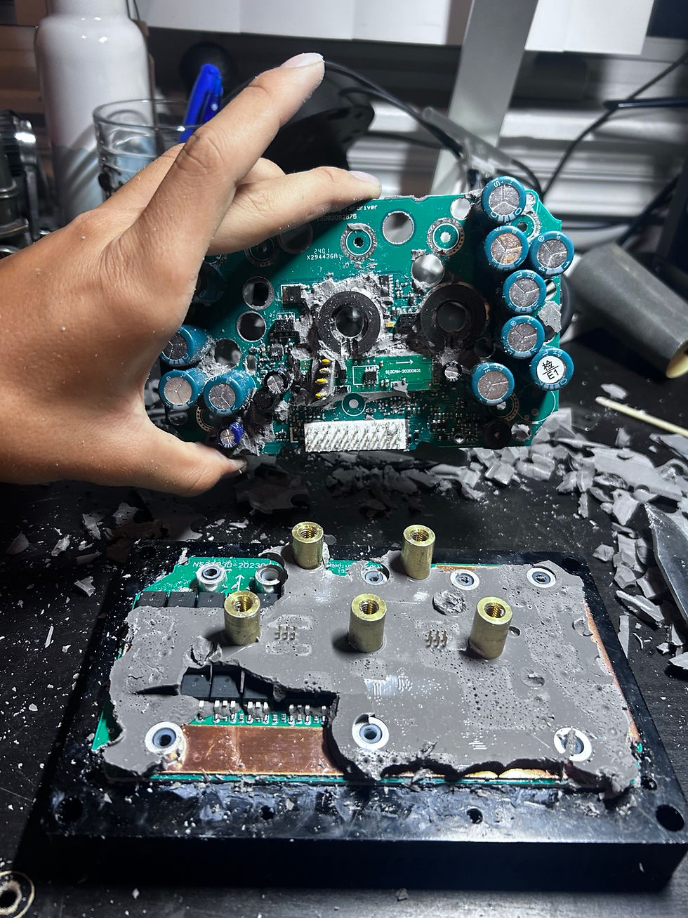 Motor controller opened into two circuit boards while protective potting compound is removed for diagnosis.