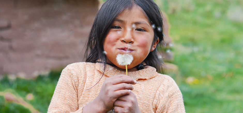 Little native american girl blowing dandelion flower..jpg