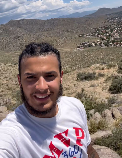 Young man smiling on a mountain with MVP 360 Sports on shirt