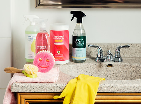 Apartment bathroom sink displaying organic cleaning products and scrub daddy