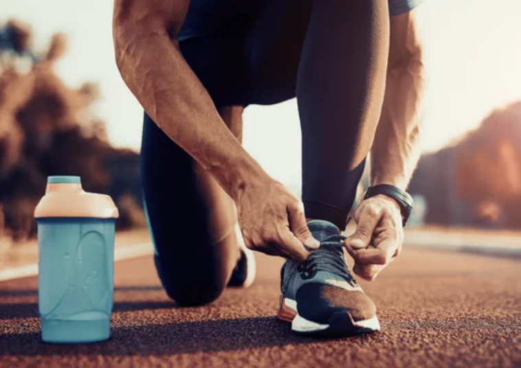 homme qui attache ses chaussures de course