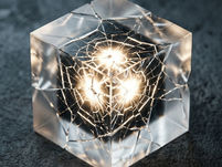 A translucent cube under pressure, glowing from within as fine cracks spread across its surface, suggesting contained force beginning to break free.