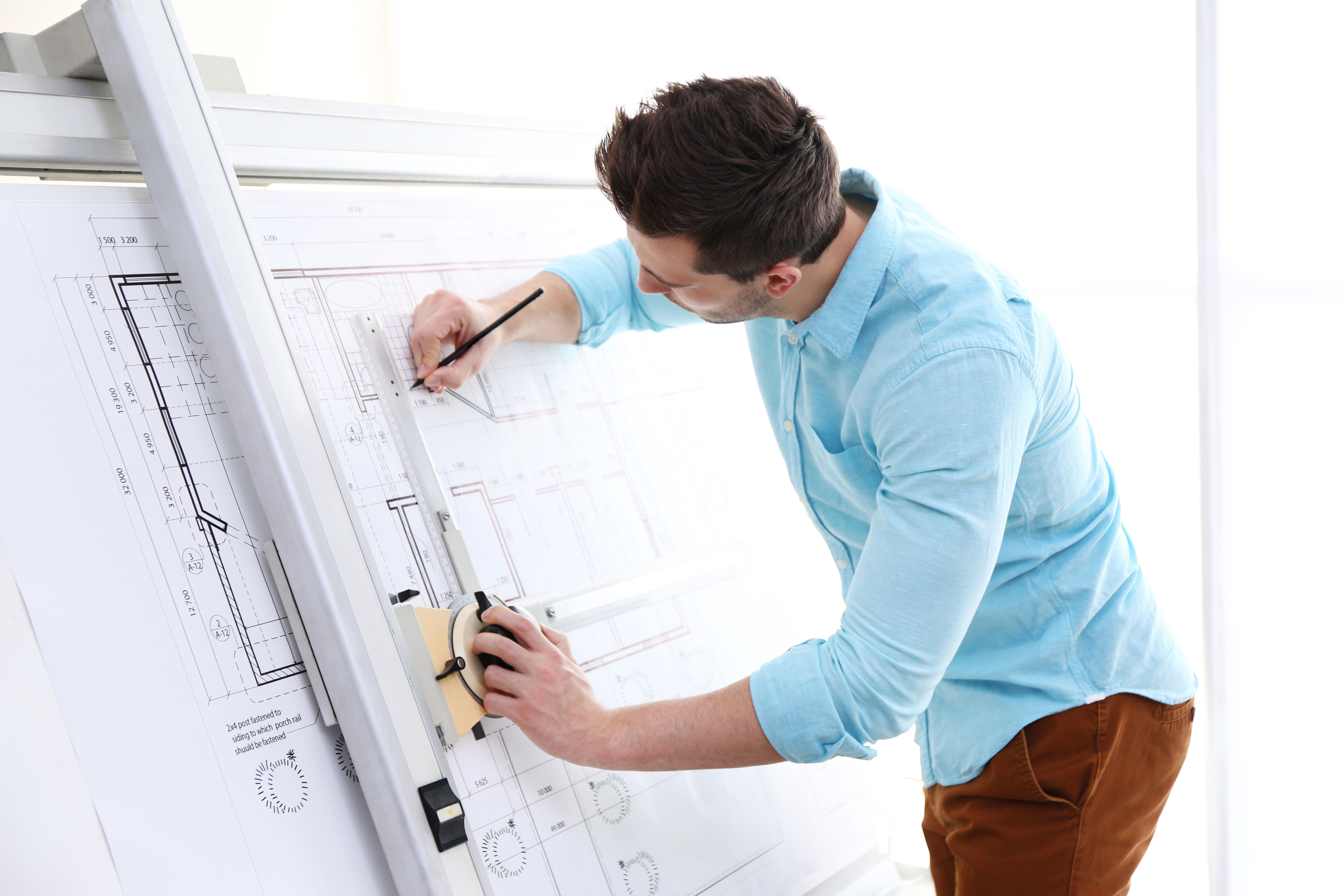 Man at a large drawing board creating plans