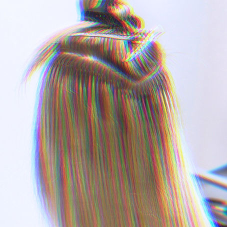 rear view of a woman getting a hair extension installation at a salon