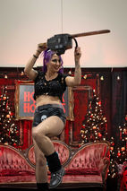 Janie Slash performing on stage with chainsaw at Horror For The Holidays