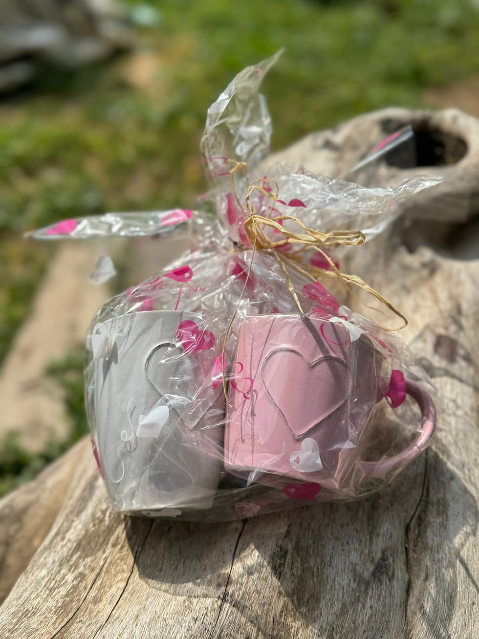 זוג ספלים ורוד ולבן עם לבבות, עטופים למתנה עם סרט