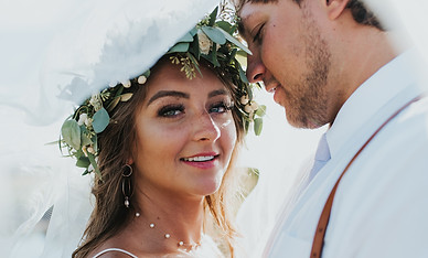 a portrait of a bride and groom showcasing her baby's breath designed flower crown