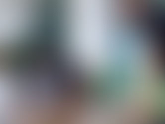 Three men collaborating around laptops at a conference table, working together on a project in a modern conference room.