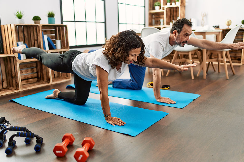 Middle age hispanic couple smiling happy stretching on the floor at home.jpg