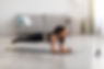 Joyful young lady in sportswear planking in living room, watching fitness video or having