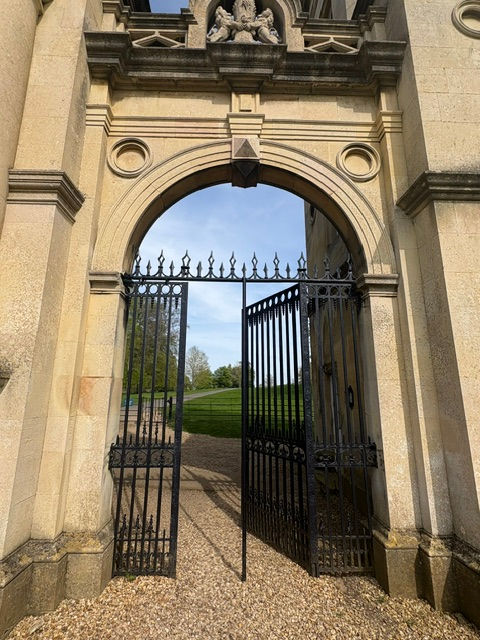 Open stone gate leading into a peaceful garden path, symbolizing entering God’s presence with thanksgiving