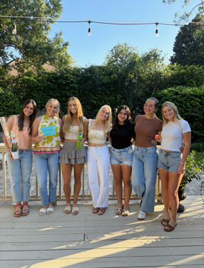 UNF Women’s Tennis Team standing together and smiling, a beautiful moment of friendship and gratitude
