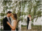 A bride and groom embrace under a willow tree beside the water in Delaware Park Buffalo.