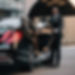 African Chauffeur Opening the door of a 2023 Black Mercedes S Class to a client providing