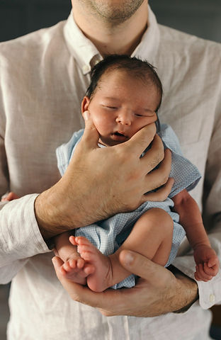 New parents lovingly gazing at their newborn baby in their arms, a tender moment from a lifestyle newborn photography session