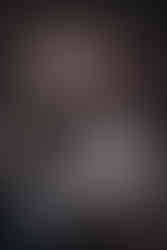 bride standing on rock in river in front of rushing water at shady lake in arkansas