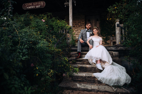 bride and groom sitting on steps of cottage at the rose emporium
