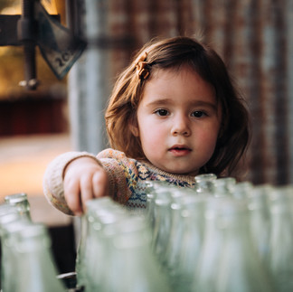 little girl playing with old coke bottles
