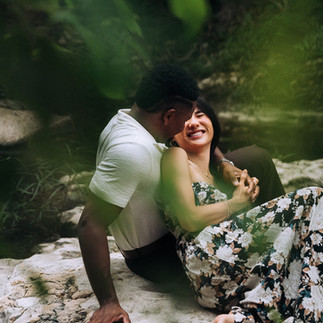 couple sitting on rock in creek