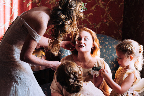 bride touching up makeup on mother
