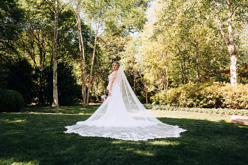 bride standing in open small grassy area at the Dallas Arboretum and Botanical gardens in Dallas Texas