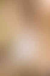 senior girl sitting among the bald cypress tress on the Pedernales River in a white dress