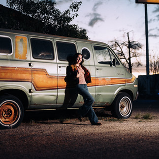 girl standing against old van