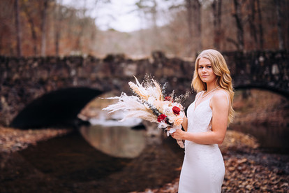 bride standing in front of rock bridge at shady lake in the ouachita mountains in arkansas