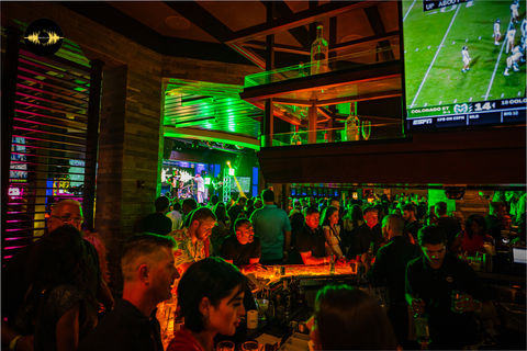 The DJ spins a captivating set, energizing the crowd at a popular Latin bar
