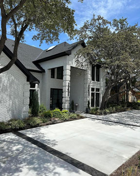 Newly designed and installed colored concrete driveway with large concrete pads separated by black colored concrete lines for a modern, contemporary look in Southlake, TX.