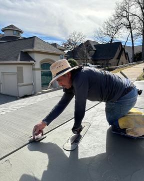 The Pro Quality team adds control joints into newly paved concrete for a driveway, ensuring proper expansion and contraction of the surface in Murphy, TX.