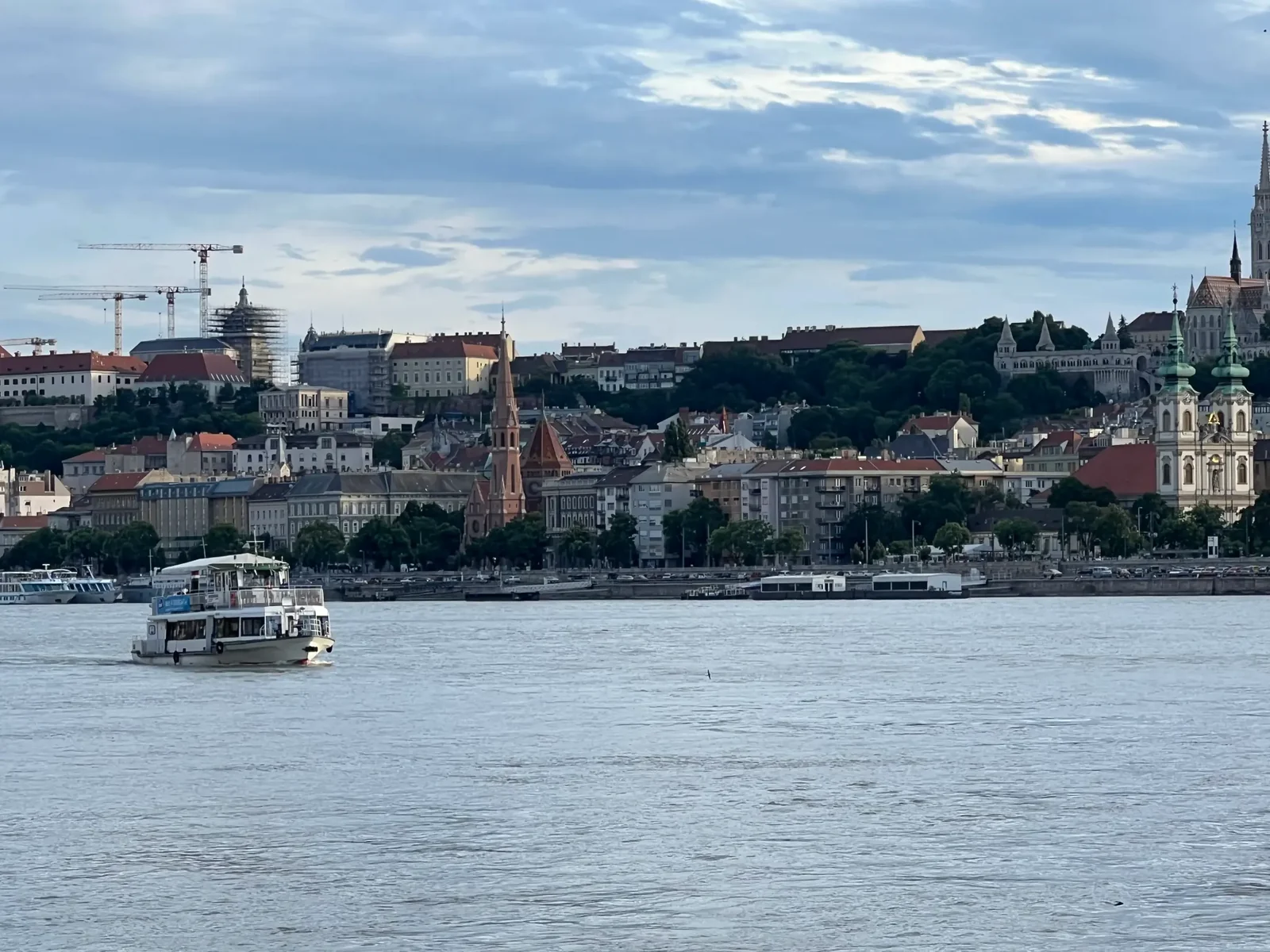 Private boat cruise Budapest view on the Danube, Budapest skyline with Buda Castle and riverside buildings in the background.