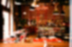 Interior of Spiler Bar in Budapest during a ruin bar crawl, showing empty tables, bar shelves with bottles, and the atmosphere before the nightlife crowd arrives.