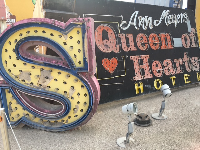 Scattering of old neon signs, including a letter S and a Queen of Hearts Hotel sign