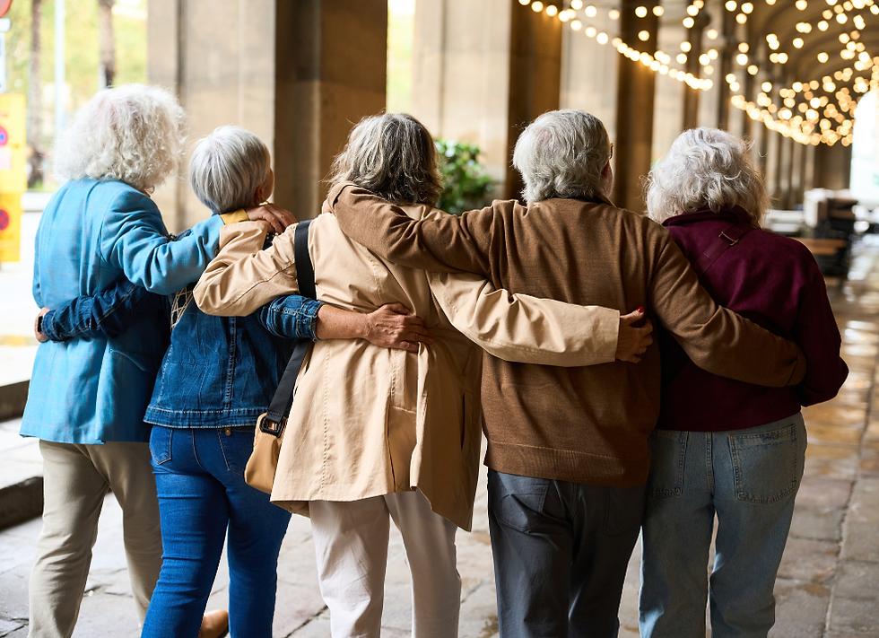 Group of older women arm in arm pictured from behind.