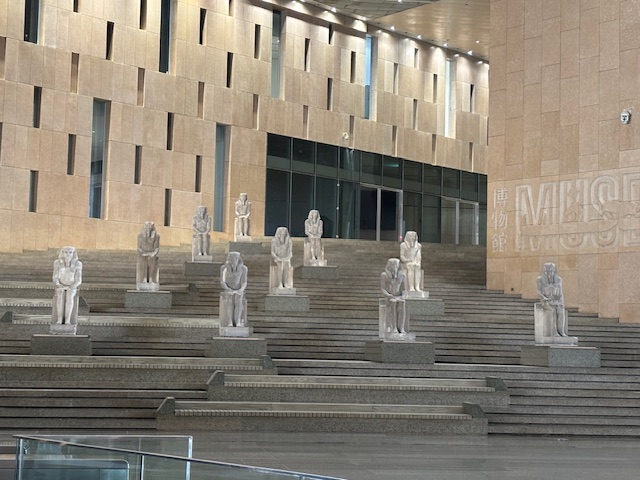 Statues of Egyptian rulers placed on stairs in the Grand Atrium of the Grand Egyption Museum