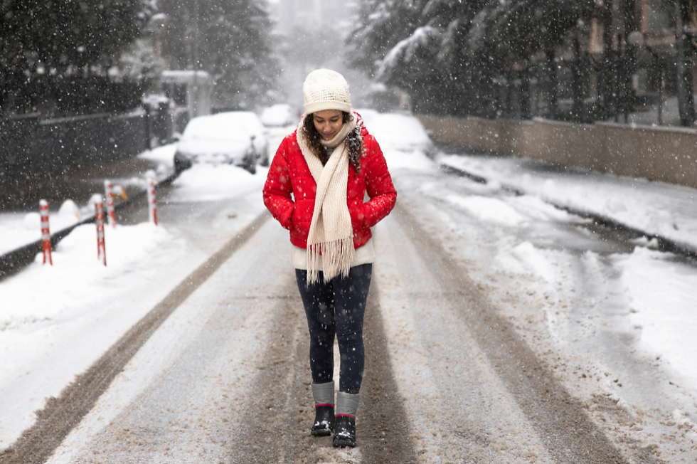 Woman in red coat walking outdoors on a snowy path