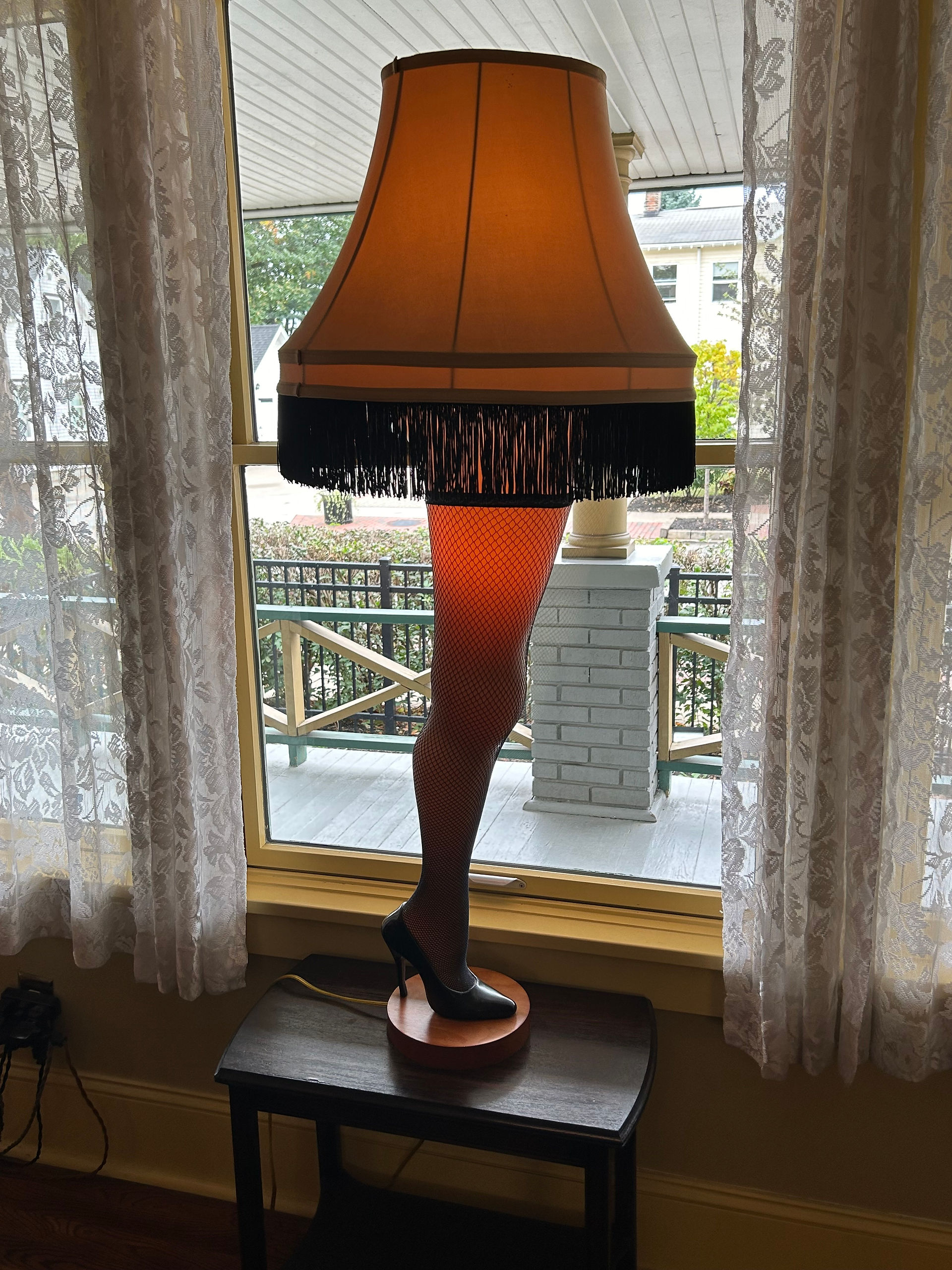 Leg-shaped lamp sitting on a table in front of a window