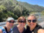 Three women on a hike in the mountains taking a selfie photo.