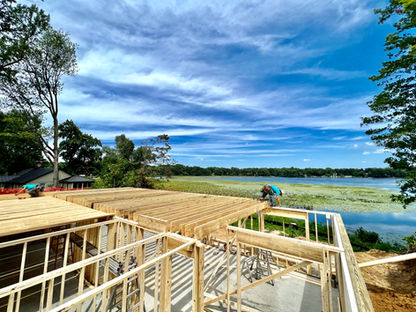 Lakefront home wall framing in progress with framed walls overlooking the water