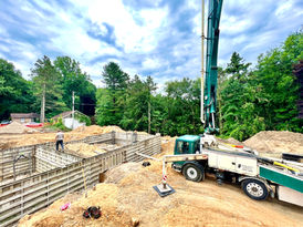 Concrete being pumped into foundation forms during a lakefront home foundation pour