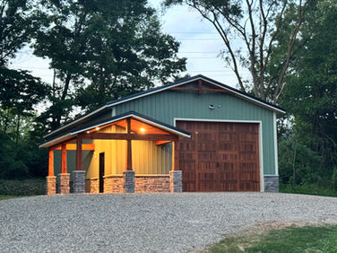 A custom post-frame storage building with a wrap-around porch, designed to blend durability with lakeside character.