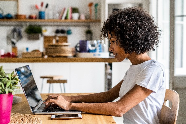 Unternehmerin sitzt am PC und macht SEO selbst, um im Google Ranking gefunden zu werden